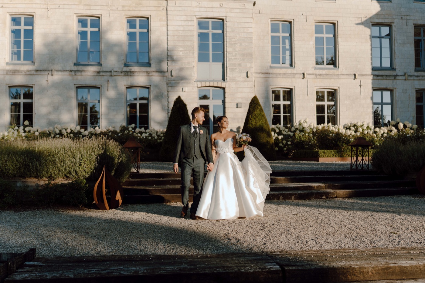 Reportage photo de mariage, mariés devant un château au coucher du soleil