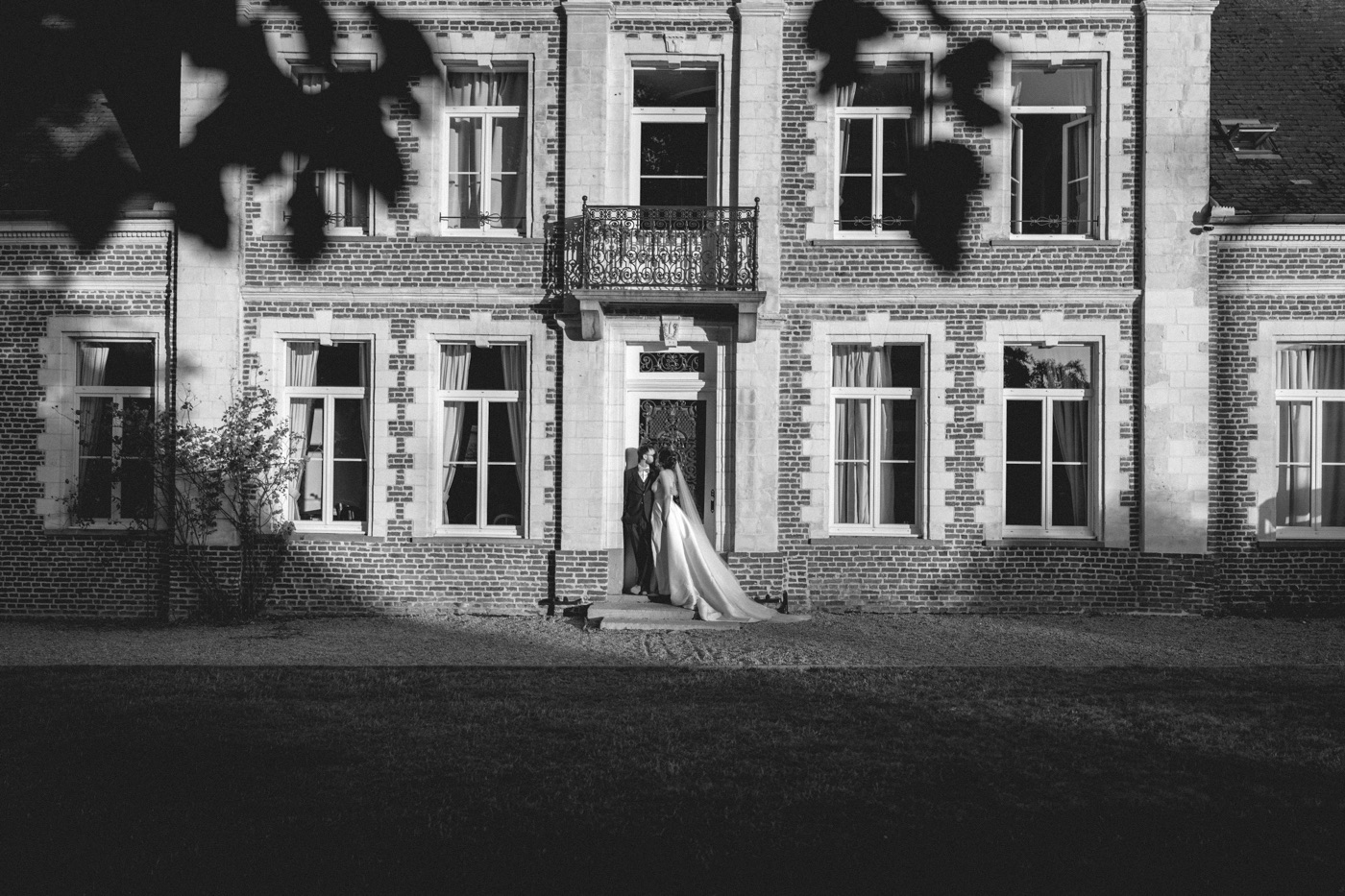 Mariés devant un château, reportage photo en noir et blanc