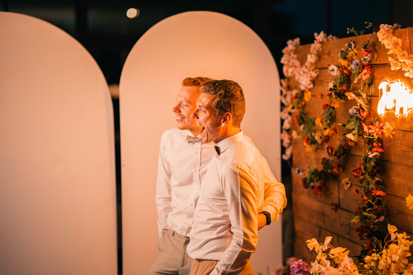 Invités posant devant le décor du photobooth lors d'un mariage